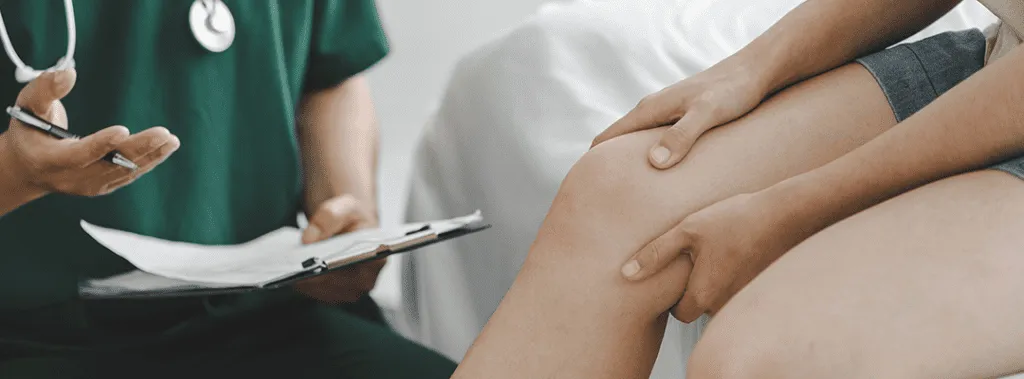 Doctor consulting with patient about knee treatment in clinic