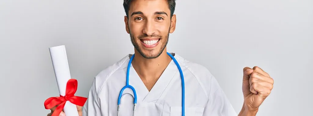 Happy male doctor celebrating graduation, holding diploma with a stethoscope around his neck